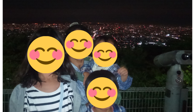 生駒山上遊園地から大阪平野の夜景と記念写真を撮る親子